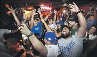  ?? Allen J. Schaben Los Angeles Times ?? FANS CHEER the Dodgers’ Game 1 victory Tuesday at the Short Stop bar near Dodger Stadium.