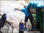  ?? ?? Henry Spillman (from right), Smith and Dorien Bryant with Bayou Services Moving load Mardi Gras costume pieces Oct. 12 from the Central School Arts and Humanities Center.