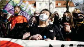  ??  ?? Elzbieta Podlesna and Anna Prus join people who gathered in solidarity with them, after the Polish LGBT activists were accused of offending religious beliefs by putting a rainbow on a painting of Virgin Mary, in Plock, Poland, March 2, 2021