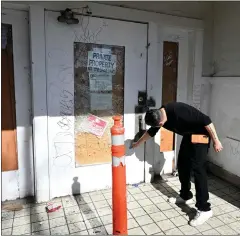  ?? ?? American Legion Post #30Post commander Javier Hinostroza checks the heavily damaged front doors of the facility located on Holt Avenue on Friday. The post has been a mainstay in the city for more than 50years.