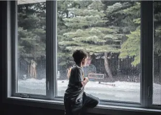  ?? AARON VINCENT ELKAIM NEW YORK TIMES ?? Lucas Parobek, 8, looks at his family’s melting homemade ice rink in Waterloo.