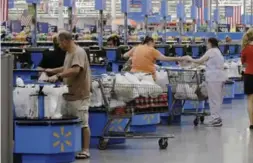  ?? DANNY JOHNSTON/THE ASSOCIATED PRESS ?? Wal-Mart investors got a closer look Tuesday at the earnings impact of the company’s move to boost pay to at least $10 an hour.