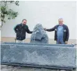  ?? FOTO: PITT SEGER ?? Der neue Dorfbrunne­n in Wengen mit Steinmetz Daniel Kortmann (links) und Toni Reichart, der immer wieder den Dorfplatz herrichtet.