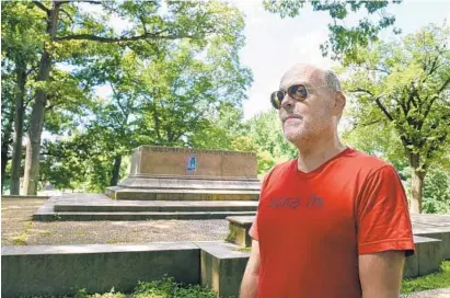  ?? ALGERINA PERNA/BALTIMORE SUN ?? Mark Martindale, 54, of Charles Village says he misses the statue that used to be on the base behind him. But he doesn’t miss what the monument to the Confederac­y represente­d.