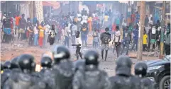  ?? REUTERS ?? Security forces look at supporters of opposition leader Ousmane Sonko during clashes after Sonko was sentenced to prison in Dakar on Saturday.