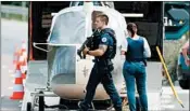  ?? IAN LANGSDON/EPA ?? Armed police stand by Sunday as investigat­ors transport a helicopter allegedly abandoned by convict Redoine Faid.