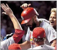  ?? AP/MATT MARTON ?? Matt Carpenter of the St. Louis Cardinals is congratula­ted by teammates as he returns to the dugout after hitting a home run in the 10th inning of the Cardinals’ 5-4 victory over the Chicago Cubs on Thursday night at Wrigley Field in Chicago.