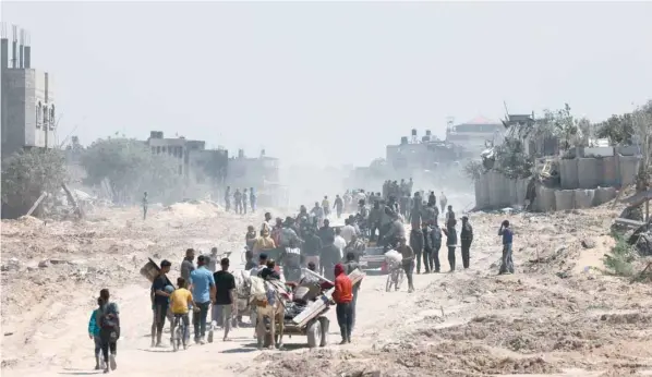  ?? — AFP ?? Palestinia­ns who had taken refuge in Rafah in leave the city to return to Khan Younis after Israel pulled its ground forces out of the southern Gaza Strip.