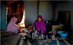  ?? AP ?? A Sahrawi family prepares breakfast inside their tent on the outskirts of Boujdour refugee camp.