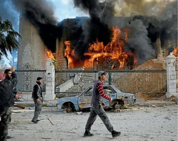  ??  ?? Civilians and firefighte­rs arrive to extinguish a blaze after Assad regime forces carried out an air strike against the de-escalation zone in Douma town of eastern Ghouta in Damascus yesterday. It is reported that 15 civilians died as a result of the...