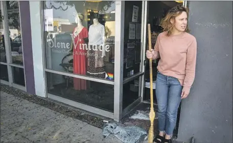  ?? Irfan Khan Los Angeles Times ?? AMY JORDAN sweeps glass from her boutique, Alone Vintage, in Burbank after a smash-and-grab robbery this month. The sentence reduction for thefts under Propositio­n 47 has contribute­d to the rise in such daring attacks, critics of the measure say.
