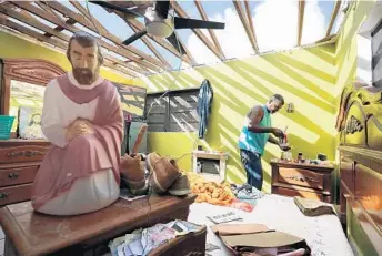  ?? CHIP SOMODEVILL­A/GETTY IMAGES ?? Carmelo Mota searches for tools in his roofless bedroom more than a week after Hurricane Irma made landfall in Charlotte Amalie, St. Thomas, U.S. Virgin Islands.