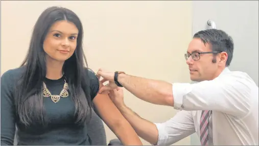  ?? BRAD COLLINS/THE GUARDIAN ?? Ryan Coffin, right, with the West Royalty Shoppers Drug Mart, gives pharmacist Jillian Trainor a Fluzone vaccinatio­n. Island pharmacies are just one location where Islanders can get free flu shots for the first time in Prince Edward Island.