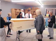  ??  ?? Community members tour the Fathers Building Futures casket and urn workshop as part of the Before I Die festival last year. The nonprofit organizati­on serves fathers who were formerly incarcerat­ed.