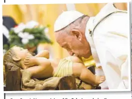  ??  ?? Pope Francis kisses a statue of the Baby Jesus during the Christmas Eve service at St. Peter’s Basilica Tuesday.