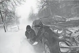  ?? DEREK GEE/THE BUFFALO NEWS VIA AP ?? Gamaliel Vega tries to dig out his car on Lafayette Avenue after he got stuck in a snowdrift about a block from home while trying to help rescue his cousin, who had lost power and heat with a baby at home across town, during a blizzard in Buffalo on Dec. 24, 2022.