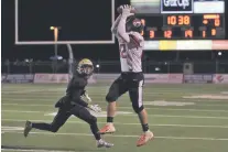  ?? COURTESY CAITIE IHRIG/LAS VEGAS OPTIC ?? Robertson running back Antonio Padilla makes a catch as a Hope Christian defender looks on Friday. The fifth-seeded Cardinals upset the No. 1 Huskies, 25-17.