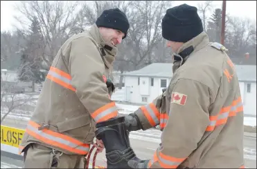  ?? NEWS PHOTO MO CRANKER ?? Firefighte­r B.J Lang reaches into a boot to get a donation out of it Sunday morning on top of the Maple Avenue Fire Station. Lang and firefighte­r Dave Kowalchuk spent two days on top of the fire hall while raising money for muscular dystrophy — it was...