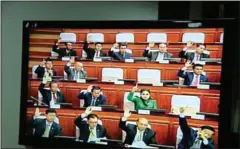  ?? HONG MENEA ?? Seen on a TV monitor, lawmakers vote to approve the draft law on nationalit­y at the National Assembly on Thursday.