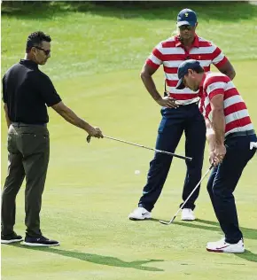  ??  ?? Practice makes perfect: US Team assistant captain Tiger Woods watching a chip shot by Brooks Koepka during practice for the Presidents Cup at Liberty National Golf Course on Tuesday. — Reuters