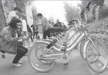  ??  ?? People examine Mobikes at a creative industry center in Beijing.