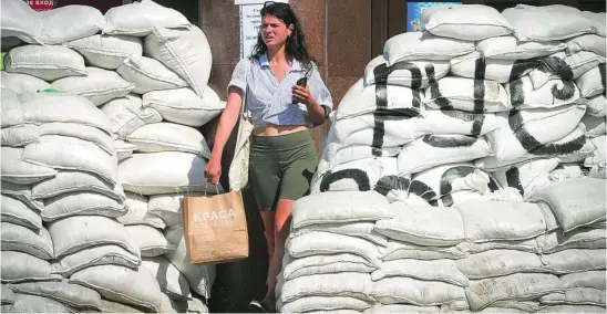  ?? AP ?? Una ucraniana pasa por una barricada en el centro de Kyiv, ayer