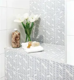  ??  ?? Pour optimiser l'espace, un petit banc qui fait aussi office de tablette a été construit dans la douche. Introduite à travers les carreaux de céramique blanche, la céramique bleue posée en chevrons crée un effet visuel fort intéressan­t.