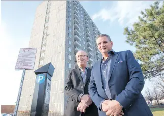  ?? WAYNE CUDDINGTON ?? Chris Hawley, VP operations, and John Lago, president of Q Residentia­l, stand outside 1240 Donald St., where they are making 150 apartments available to Syrian refugee families.
