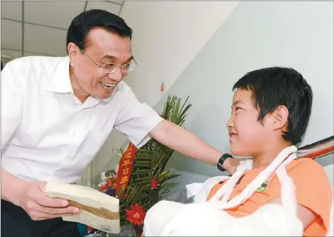  ?? LIAO PAN / CHINA NEWS SERVICE ?? Premier Li Keqiang visits 12-year-old earthquake victim Cao Jiandong in Minxian county, Northwest China’s Gansu province, on Saturday. The county was hit by an earthquake on July 22.
