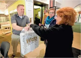  ??  ?? Watts CEO Sam Watts, a fifth-generation Watts, hands a purchase to Linda Drake (right) of Milwaukee last week as Roseann Preuss of Milwaukee looks on.