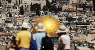  ?? (Ammar Awad/Reuters) ?? TOURISTS PEER out at the Dome of the Rock. Israel is preparing for its four millionth visitor, who is likely to arrive within the next few weeks.