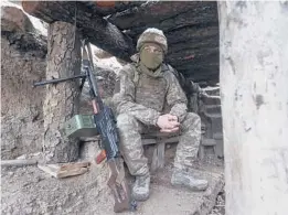  ?? ANDRIY DUBCHAK/AP ?? A Ukrainian soldier sits in a fighting position Friday on the line of separation from pro-Russian rebels near Debaltsevo, Donetsk region, Ukraine.