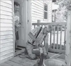  ??  ?? Tony Dorrian, left, co-chairman of the St. Ambrose refugee committee in Yarmouth, looks on from the doorway as Garnet Banks does some work on the house that volunteers have prepared for a Syrian refugee family coming to Yarmouth.