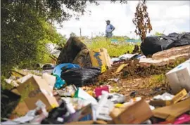  ?? Annie Mulligan Houston Chronicle ?? PILES OF TRASH near a Houston street. The Justice Department says illegal dumping in the city disproport­ionately burdens Black and Latino communitie­s.