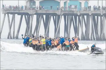  ?? Photog r aphs by
Allen J. Schaben
Los Angeles Times ?? SURF CHAMPIONS, celebritie­s and local heroes broke the Guinness World Record for “Most People Riding a Surf board at Once.” The Huntington Beach event was part of the celebratio­n of Internatio­nal Surfing Day.