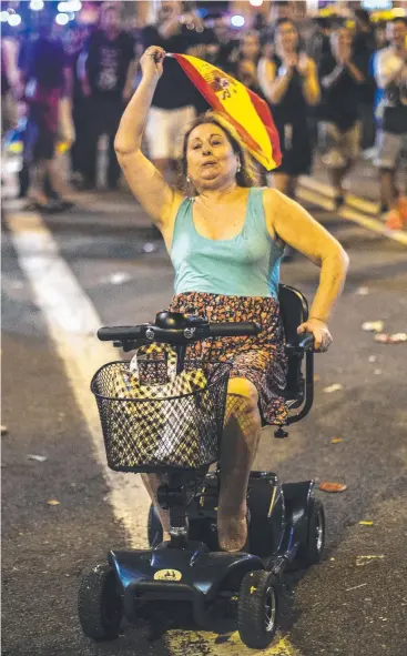  ?? Picture: AP ?? FIRED UP: A woman waves a Spanish flag at a march against police violence in Barcelona.