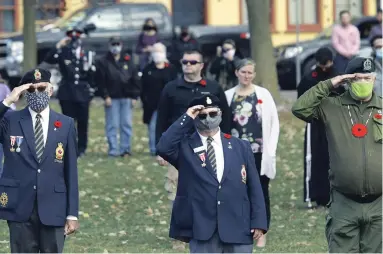  ?? CLIFFORD SKARSTEDT EXAMINER ?? Veterans salute during the playing of the “Last Post” during a Remembranc­e Day service held at Confederat­ion Square on Wednesday. About 100 people observed COVID-19 protocols during the service honouring the fallen soldiers.