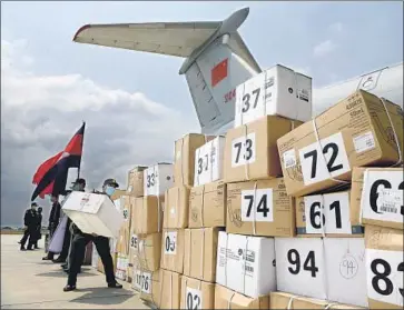  ?? Tang Chhin Sothy AFP/Getty Images ?? A CAMBODIAN soldier helps unload aid supplies from a Chinese military plane at Phnom Penh Internatio­nal Airport this month. Chinese President Xi Jinping has declared a “people’s war” against the coronaviru­s.