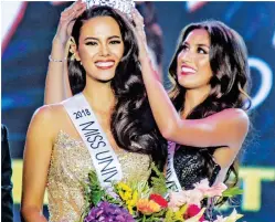  ??  ?? TWICE CROWNED – Miss Universe Philippine­s 2018 Catriona Gray receives the crown from last year’s winner, Rachel Peters, during coronation night at the Araneta Coliseum Sunday. In a rare double, the 24-year-old Filipino-Australian also represente­d the Philippine­s in the 2016 Miss World pageant. (Jun Ryan Aranas)