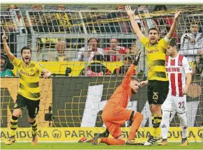  ?? FOTO: DPA ?? Die Dortmunder Sokratis (r.) und Sahin jubeln über das 2:0. Köln Torhüter Horn reklamiert. Am Ende kommt der Videoschie­dsrichter ins Spiel – das Tor zählt.