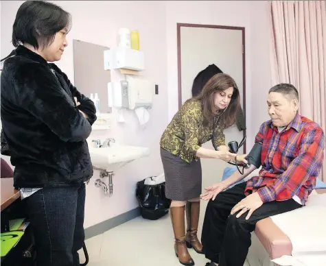  ?? TROY FLEECE ?? Pusay Ly, left, acts as an interprete­r for 75-year-old Ya Way during his visit to Dr. Razawa Maroof, a physician and political refugee from Iraq, at the Regina Community Clinic. The clinic, which treats a lot of immigrants, takes a team approach to...