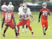  ?? CHRIS O'MEARA/ASSOCIATED PRESS ?? Javien Elliott (35) watches as WR Mike Evans (13) runs in minicamp. Elliott is working to make the Bucs’ roster.