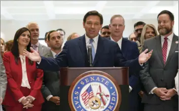  ?? AP PHOTO/WILFREDO LEE ?? Surrounded by lawmakers, Florida Gov.Ron DeSantis speaks at the end of a legislativ­e session, Friday at the Capitol in Tallahasse­e, Fla.