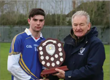  ??  ?? Coláiste Bhríde Carnew captain Conor Hughes collects the South Leinster trophy from Pat Henderson.