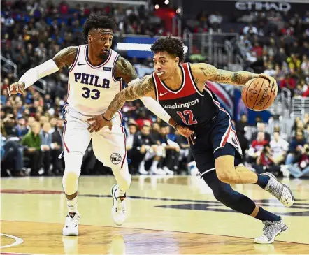  ??  ?? Out of my way: Washington Wizards forward Kelly Oubre Jr (right) dribbling past Philadelph­ia 76ers forward Robert Covington during the NBA game at the Capital One Arena on Sunday. — Reuters