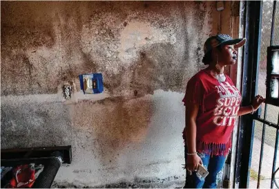  ?? Brett Coomer / Houston Chronicle ?? Victims of Hurricane Harvey’s floodwater­s may still be suffering from the trauma of the loss. Koffey Smith, standing at the door of her print shop, now has to deal with mold issues brought on by the disaster.