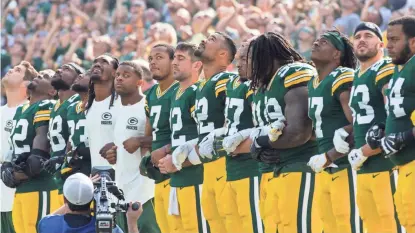  ?? jsonline.com/sports. MARK HOFFMAN / MILWAUKEE JOURNAL SENTINEL ?? Members of the Packers lock arms during the singing of the national anthem before their game against the Bengals at Lambeau Field on Sunday. For complete game coverage, see Sports and