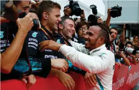  ??  ?? Mercedes’ Lewis Hamilton celebrates winning the race with team members