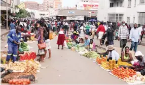  ??  ?? Vendors sell agricultur­al produce at an undesignat­ed place along Speke Avenue in Harare yesterday without observing Covid-19 regulation­s. — Picture : Kudakwashe Hunda