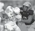  ?? RICK SCUTERI/AP ?? Arizona State linebacker Merlin Robertson (8) tackles Kent State quarterbac­k Dustin Crum (14) during a game on Aug. 29, 2019, in Tempe.